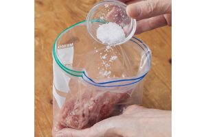 1.ひき肉を冷凍用保存袋（18×20cm）に入れ、塩を加えてよくもみ込む。先に塩を加えることで肉同士を結着させ、うまみを引き出す。