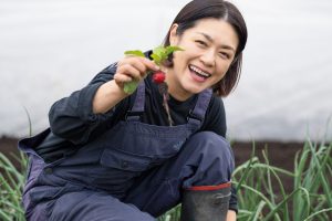 野菜を収穫する加藤紀子さん。