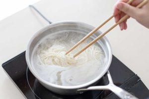 （3）鍋に湯適量（分量外）を沸かし、そうめんを茹でる。流水でもみ洗いし、ざるにあげる。