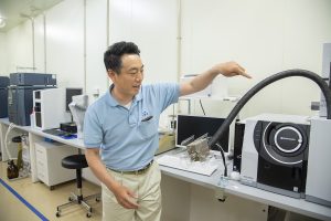 香りを分析する機械の説明をする倉橋博士。