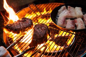 強火で肉の表面を焼き固め、弱火で魚にじっくりと火を通す。