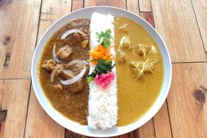 向かって左は三元豚の豚肉を柔らかく漬け込んだ「リチャージポークマサラ」、右は無農薬のレモンピールのほろ苦い香りがアクセントの「リカバリーレモンチキン」。カレーは1種盛り（1,300円〜1,450円）と、写真の2種盛り（1,500円〜1,650円）から選べる。