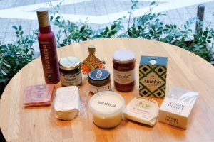 今回パンと合わせた商品は一部の店舗を除き、ディーン＆デルーカで購入可能。左奥から時計回りで「ブラボレウム　エキストラバージンオリーブオイル　ピクアル」「BEAUFOR コルニッション」「エミコット　メープルシロップアンバー」「ハッピーナッツデイ　ピーナッツバター粒あり」「イタリアンフルーツトマトのオイル漬け」「マルドン　クリスタルシーソルト」 「アカシアコムハニー」「オッチェッリバター」「Good Cheese Good Bake ストラッチァテッラ」「コパン　白かびチーズ」「エレゾ　放牧豚のテリーヌ ド カンパーニュ」 「オラッチェバター」