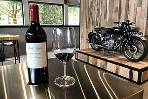 マクニーリーさんが大ファンのロックバンド、パール・ジャムから触発されたという。反体制派（THE DISSIDENT）という名前が付けられた2022カベルネ・ソーヴィニヨン。フルボディのワインは名前から想像するよりも親しみやすく味わい深い。右のバイクはマクニーリーさんのコレクション