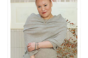 ピンク色の髪がグレーのワンピースとよくマッチ。「ヘアスタイルによって、着ている服も変わります」