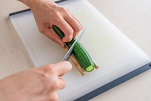 （1）きゅうりは塩を振り、板ずりをする。さっと水洗いしてペーパータオルで水気を取る。両端を切り落とし、蛇腹切りにする。（割り箸を両脇に置いて斜めに細かく切り込みを入れる。裏返して同様に切る）