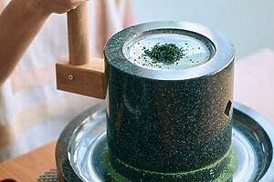 茶臼と呼ばれる石臼の穴に少しずつ碾茶を入れ、ゆっくり回し続けると下から抹茶が出てくる