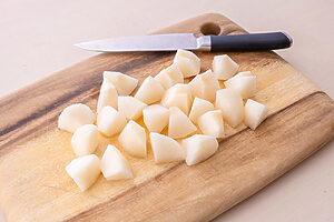 （1）梨は皮をむいて、食べやすいひと口大のぶつ切りにする