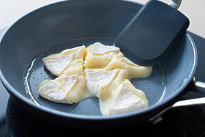 （1）フライパンにオリーブオイルを弱めの中火で熱し、チーズを入れ、おさえるようにつぶしながら焼く