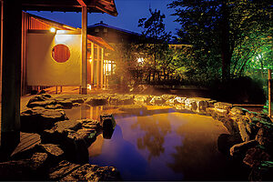 露天風呂「花」はハート形の岩風呂。夏は新緑、秋は紅葉が楽しめ、日が落ちると幻想的な景色に