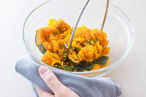 （2）かぼちゃは皮つきのままひと口大に切り、水大さじ1をふってラップをかける。電子レンジ600Wで4〜5分加熱し、竹串がスッと通るくらいになったらフォークで軽くつぶす。 半分ほど形を残す