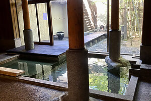 竹林の庭を眺めながらゆっくりと浸かれる赤御影石造りの女湯。高い天井と太い柱が印象的。女湯には露天風呂もある。15時〜24時、6時〜9時
