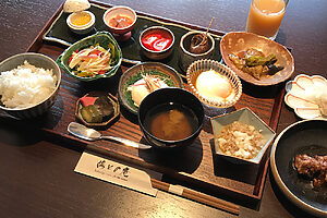 左上から、岩魚のイクラ、塩辛、井上農場の樹熟トマト、黒バイ貝煮つけ、茄子のコンソメ煮。中央左から井上農場のつや姫、山形のだし奥田風、庄内野菜の漬物、南禅寺豆腐、ギバサの味噌汁、わんぱく農場の平飼い卵の温泉卵、そばきり。トレイ右外上口細カレイの塩焼き、山形牛のトマト煮