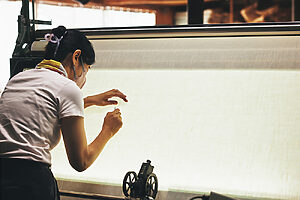 検反の様子：織り損ないがないか、人の目により丁寧に生地をチェック