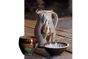 リーチ式の取っ手が美しい三彩櫛描き七寸ピッチャーは8,000円～。右は刷毛目四寸小鉢、左は三彩櫛描きカップ