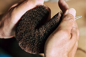 5. 亀の子の形に曲げ、専用の台座に置いて縄をかける。針金を留めて完成