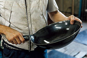 完成した、打出し片手鍋。直径40cmを超える業務用もあるが、写真は直径27cm、重さが約830gと家庭用のサイズ。鉄板を数千回叩くことで熱伝導率が高く油切れがよくなる