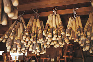 完成したすりこぎ棒は吊るし干しで保管。16cm 550円、20cm 太 1,650円、30cm 3,850円。他サイズあり。（『竹工房せきね』栃木県芳賀郡益子町七井1162-2　TEL：0285-72-4434　<a href="http://www.surikogibou.jp/" target="_blank">http://www.surikogibou.jp/</a>）