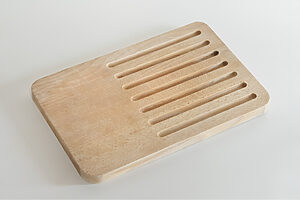ambaiのパン切り板──あちこちに飛び散らかりがちなパン屑を溝がしっかり受け止めてくれる優れもの。横の余白は「チーズなど、他のものを切ったり、ジャムを置いたりするために」と考えられたもの。「食卓で使ってほしいです」。22×30×2cm 5,500円（フォームレディ）