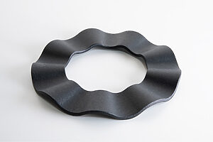 ambaiの鉄鍋敷──美しい佇まいの南部鉄鍋敷。背の高いひだの3点で支えるつくりで、裏表に関係なく置くことができ、しっかり放熱もできる。「道具は使わずに置いてある時でも情緒的な佇まいになるように意識しながらデザインをしています」。直径16×H1.3cm 6,050円（フォームレディ）