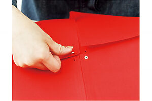 スクリューパンチで穴を開け、布を開いてカシメをつける。カシメは打ち棒と金槌を使ってしっかり固定する