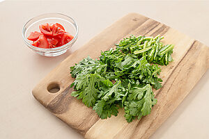 （1） 春菊は洗って水気を取り、4〜5cm長さに切る。茎の太い部分は細く切る。トマトは一口大に切る