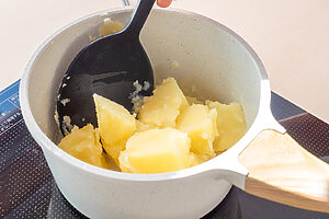 （2）じゃがいもは一口大に切り、水に5分さらす。鍋に湯を沸かし、竹串がスーッと通るまで10〜15分ほど茹でる。湯を切り、火にかけてざっと混ぜながら水気を飛ばす