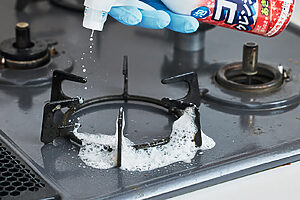 キッチンの油汚れやふきこぼれ汚れが高温で焼きつけられたコゲは、専用洗剤を吹きかけて2～3分放置する。〈コゲクレンジング〉はアルカリ性の泡がコゲに密着して強力に分解する