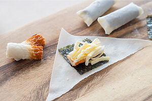 （2）春巻きの皮に海苔をのせ、ちくわとピザ用チーズをのせる