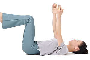 1. 床に仰向けに寝て、腹圧を入れて腰の隙間をなくす。両手足を真上に上げ、膝を曲げる