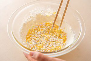 （2）ボウルに卵、水、顆粒和風だしを入れて混ぜ、薄力粉を加えてさっと混ぜる