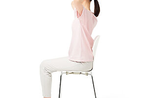 ❶椅子に座り、後頭部に両手を置く