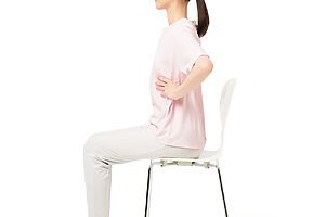 ❶椅子にやや浅めに座り、両手を肋骨の横に当てる