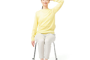 ❶椅子に浅く座り、片方の腕は横に下ろし、反対の手は頭の後ろに置く