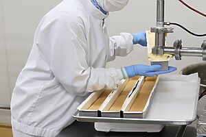 プレミアムチーズケーキのチーズクリームは、専用の抽出器からスポンジケーキの上に流し込む