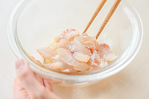 （2）ボウルにレモン汁、ナンプラー、ごま油、砂糖を入れて混ぜる。鯛を加えてやさしく和える