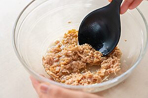 （2）ボウルに油を軽く切ったツナ、ポン酢、ごま油、にんにくを入れて混ぜる