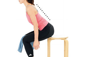 両ひざでタオルの結び目を挟み、背中をまっすぐにしたまま前に倒して「よっこらしょ」のイメージで立ち上がる