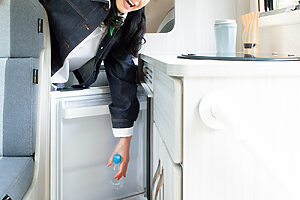 【旅の間の基本食材はこれでストック】調理台下に設置された冷蔵庫。容量は85リットルと充分なサイズ感。冷凍室も付いているので夏のキャンプはうれしい