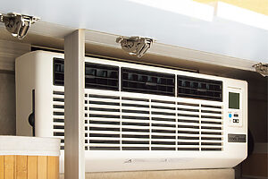 【夏に頼もしい、専用設計のエアコン】ダイネット上部にある収納棚は、オプションで大型のエアコンを取り付けることが可能。真夏の車中泊も快適だ