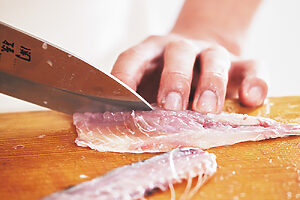 4. 腹骨のある部分は、包丁の刃を寝かし入れてそぎ落とす。さらに縦半分にカットしたら、真ん中にあった小骨の部分も切り落とす