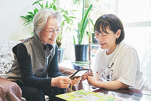 スマホで特急券の予約方法を教える手越さん（右）と、友人の石渡依子さん（左）