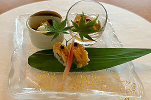 鱧前菜3種。鱧の棒寿司（中央下）。タレ焼きの鱧を炒り胡麻と大葉を混ぜ込んだ酢飯と共に棒寿司に。鱧のお浸し（左上）。淡路島産新玉ねぎと夏野菜などと鱧を和えた出汁のきいたお浸し。鱧の夏野菜ゼリー（右上）。プチトマトや茄子、オクラなどの夏野菜と鱧を上品な出汁のゼリーに閉じ込めた一品