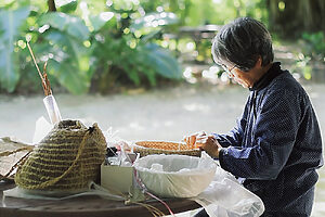豊かな自然の中、木陰で民具を編む、島らしい手仕事を体験できる