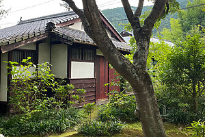 庭から見た生家。縁側の眼前に広がる庭園は、梅、桜、約100本の紅葉、美しい杉苔で彩られている