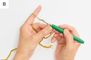 輪の交点を押さえ、かぎ針の背で糸を押すようにしながら針先に糸をかける