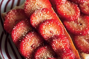 【友人の庭で過ごした 春の日の朝が甦る。いちごのタルティーヌ】バゲットに無塩バターを塗り、スライスしたいちごを並べたら、きび砂糖を景気よくふりかける。