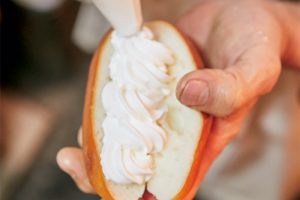 2.細長いパンにクリームを詰める。気温の高い夏場は作らないそう。