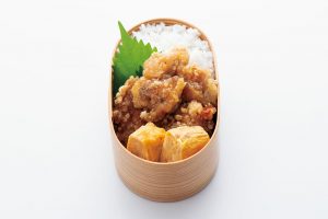 3.【形の決まったおかずを入れる。】空いた場所に卵焼きを。「深いお弁当箱には立てて、浅いお弁当箱なら横にして入れます。四角いお弁当箱なら角に入れるといいですよ」